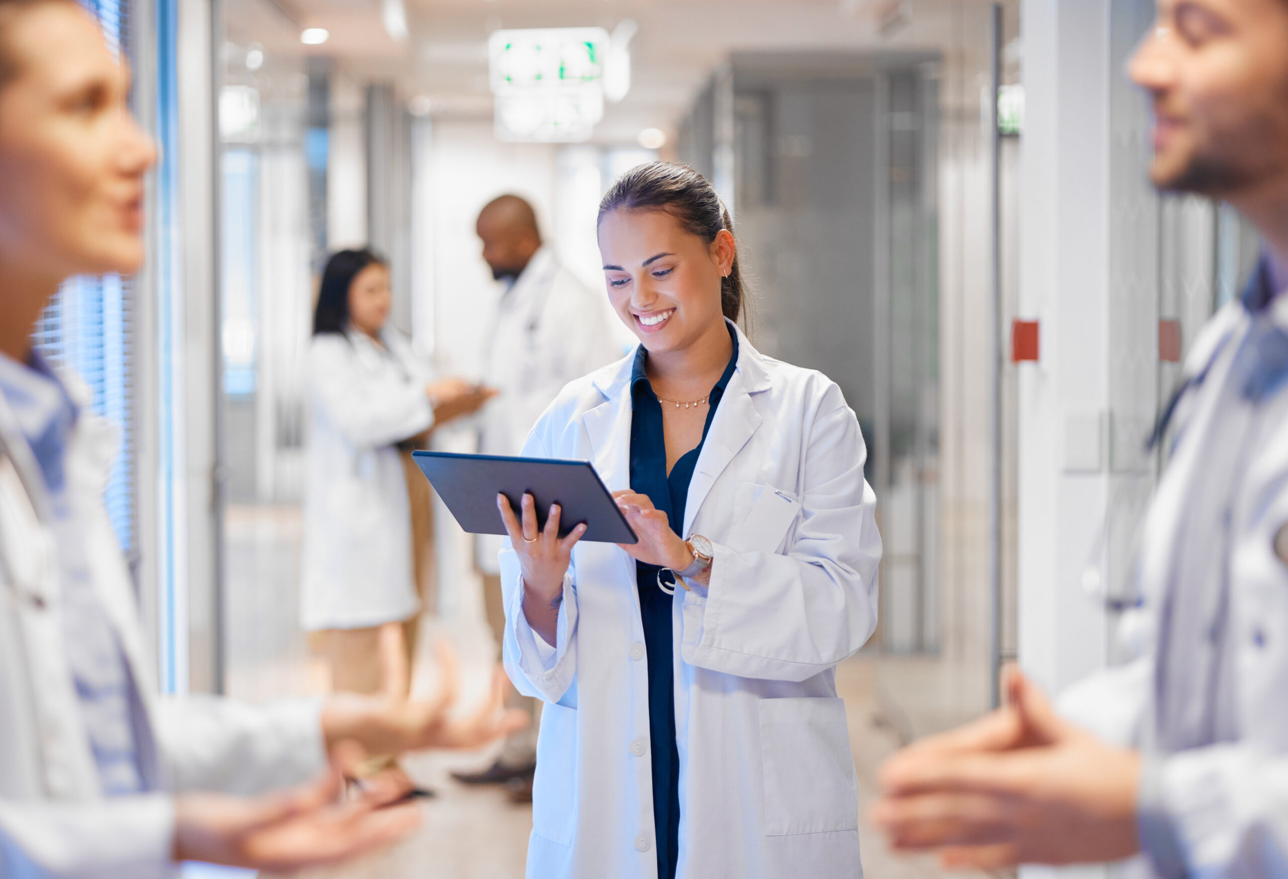 Happy woman doctor on tablet for employees management, hospital workflow and clinic staff solution on software or app. Healthcare manager on digital tech for medical team research or problem solving Zorg: Centrale coördinatie